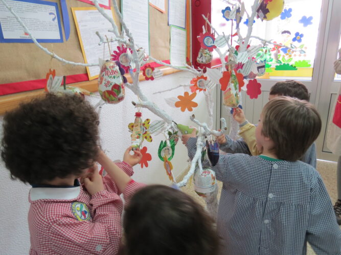 Crianças da sala heterogénea a colocarem os frutos na árvore.