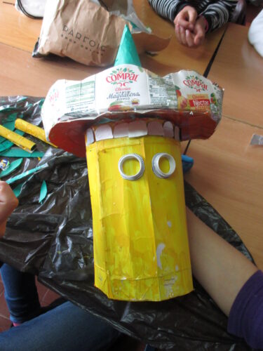 Construção da parte redonda do boneco - minium - com pacotes de Compal e dos olhos com as tampas dos pacotes.